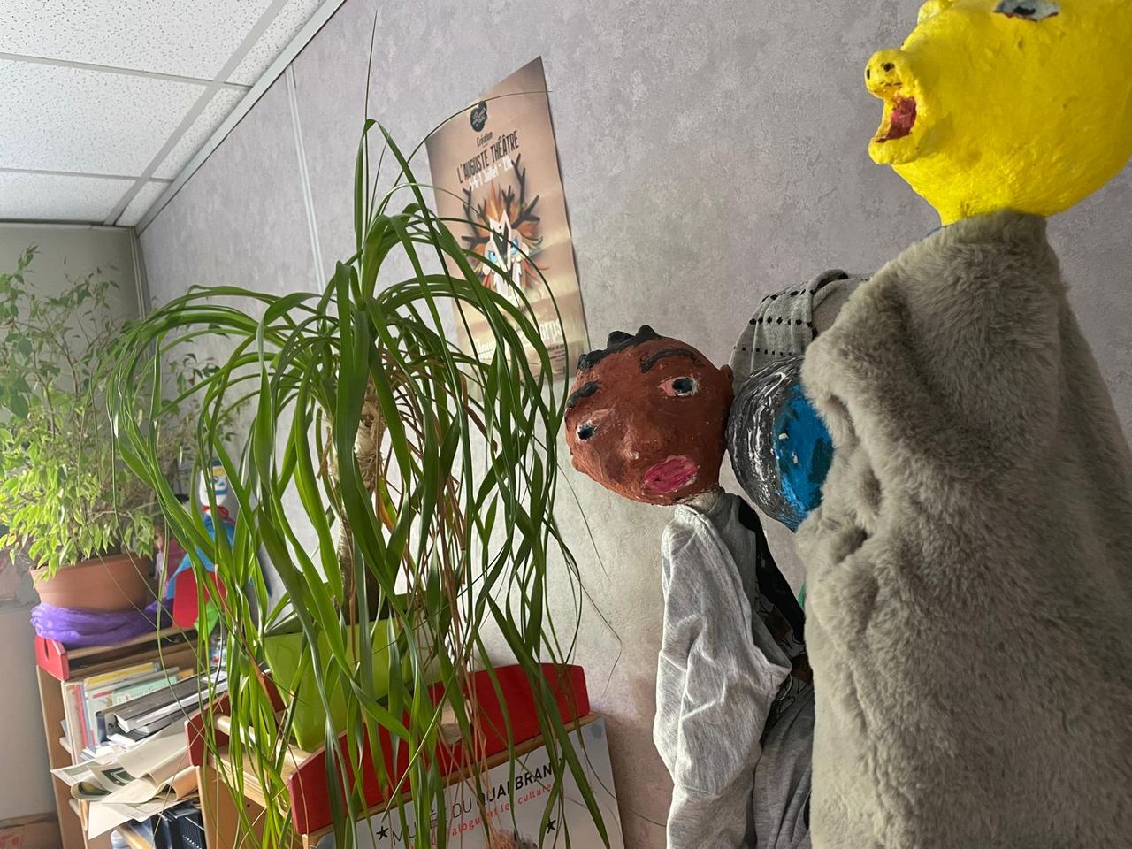 Dans une salle de consultation du CMP, des marionnettes fabriquées en papier mâché, près d’une plante verte