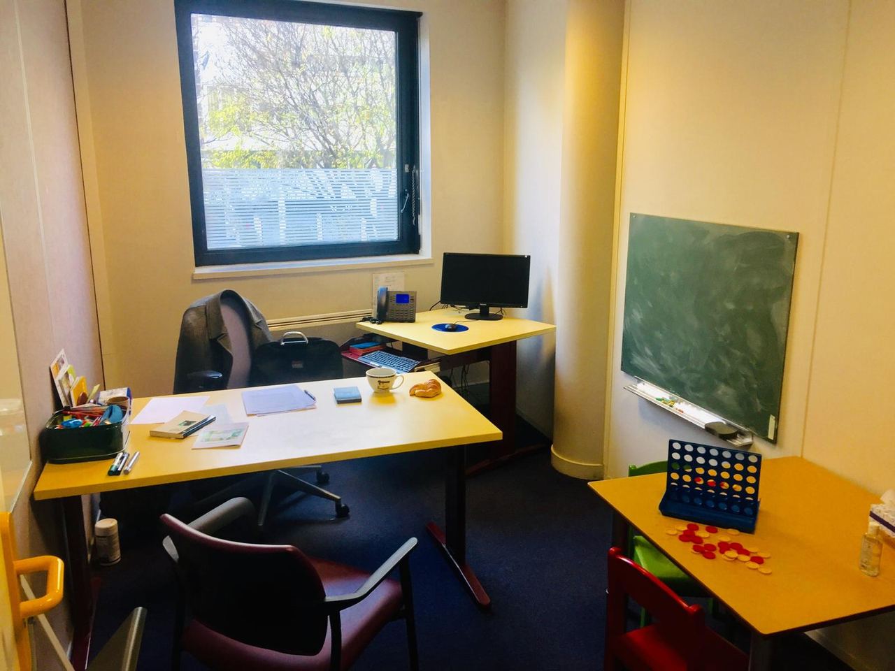 Un bureau de consultation du CMP : bureau, fenêtre, tableau et table de jeux pour enfants